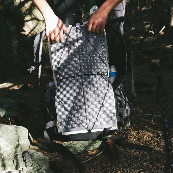 Bonfus Iterus 38L back panel shock cord system close-up - removable cords for attaching foam sleeping pad to frameless ultralight pack