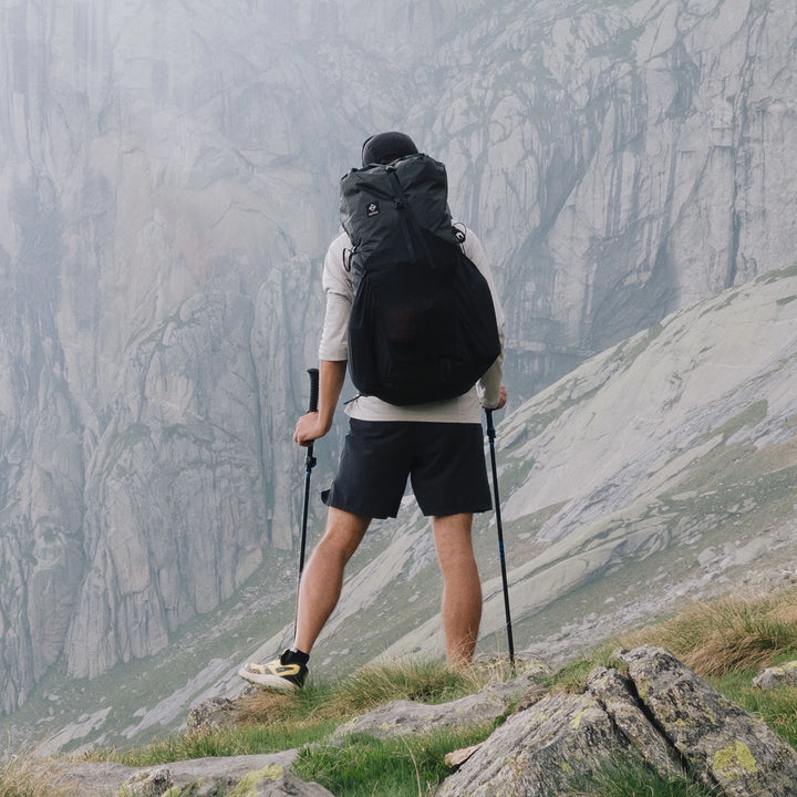 Bonfus Aerus 55L ultralight pack trail action - hiker with loaded DCF backpack in mountain terrain
