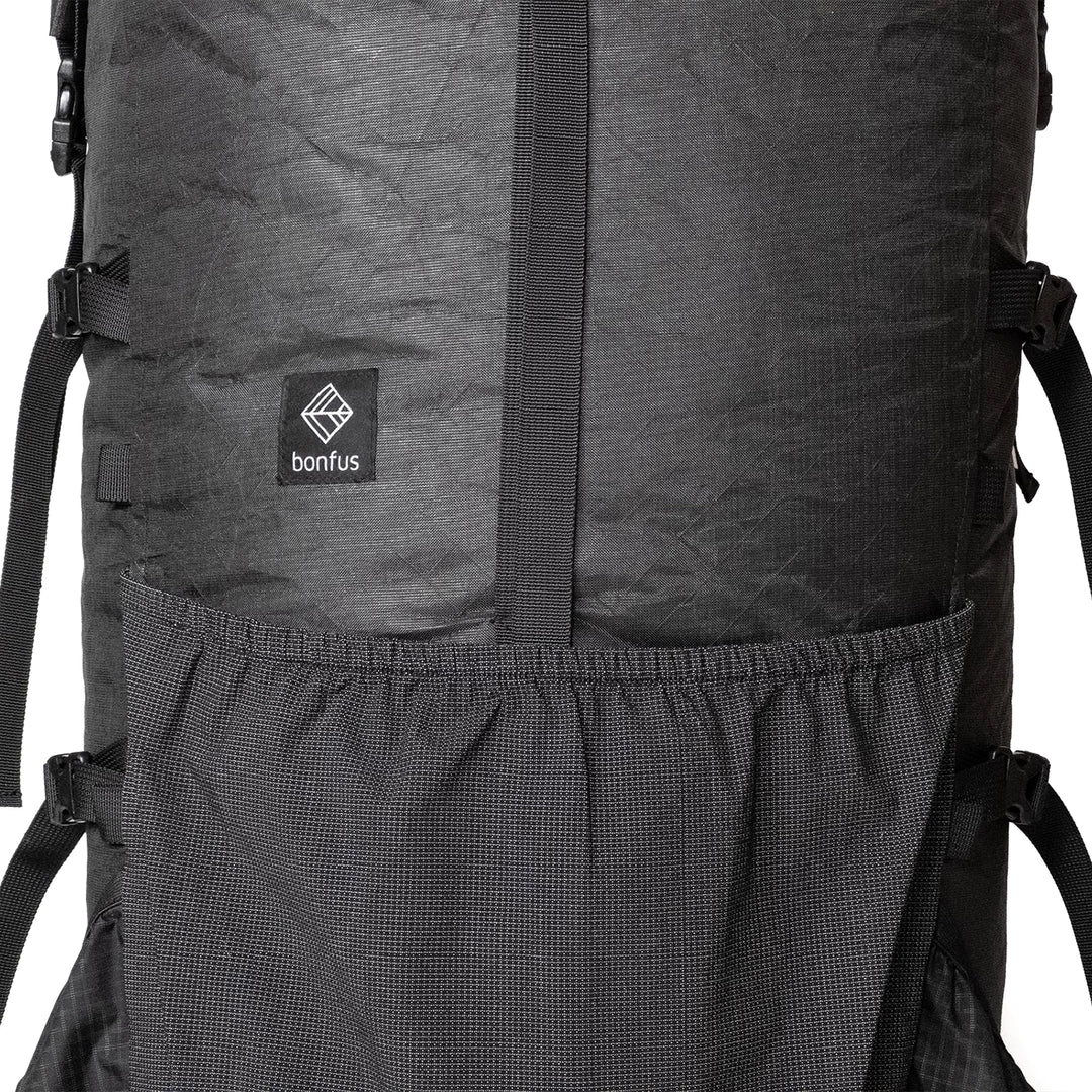 Bonfus Maxus 80L front pocket detail - stretchy mesh front pocket for quick-access gear on ultralight DCF pack