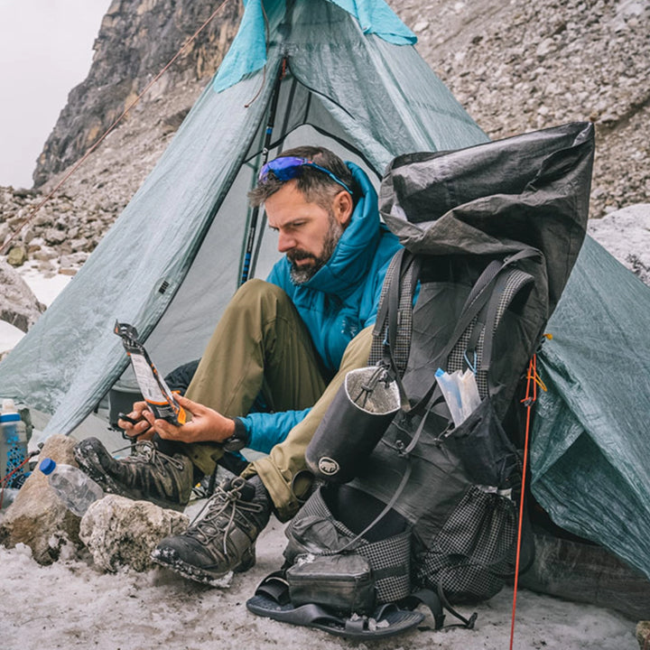 Bonfus Shoulder Pouch lifestyle photo - hiker using DCF shoulder strap pouch for phone and snacks while hiking