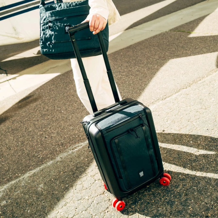 Topo Designs Global Pro Travel Roller being pulled through an airport concourse